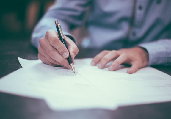 Vertragsrecht, Person bearbeitet Dokument mit Stift